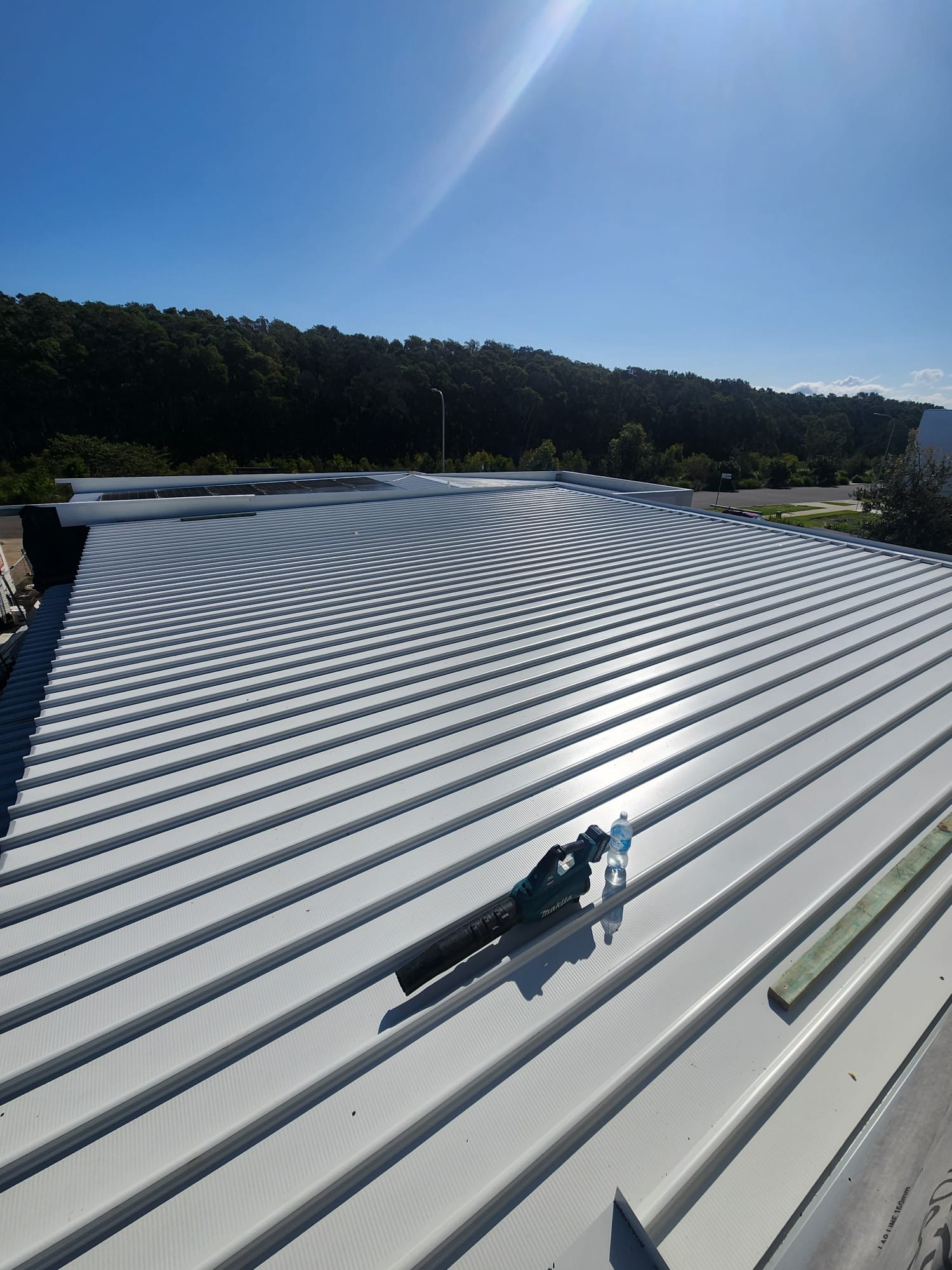 Broad view across newly installed light-coloured metal roof sheets